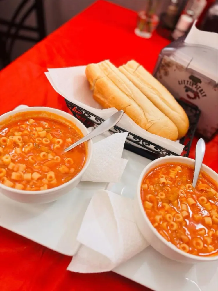 Two bowls of pasta and bean soup with bread