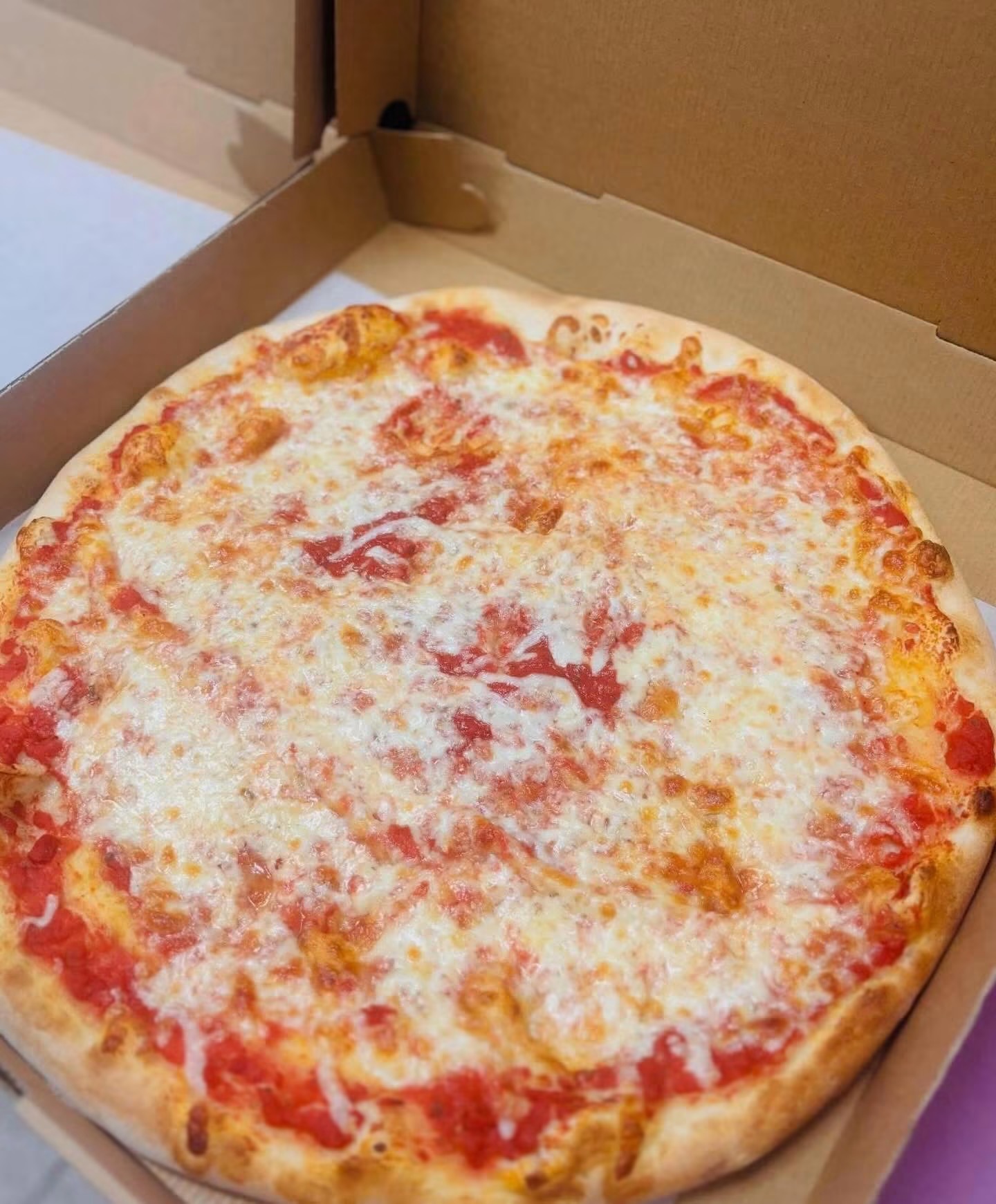 Classic cheese pizza in a takeout box