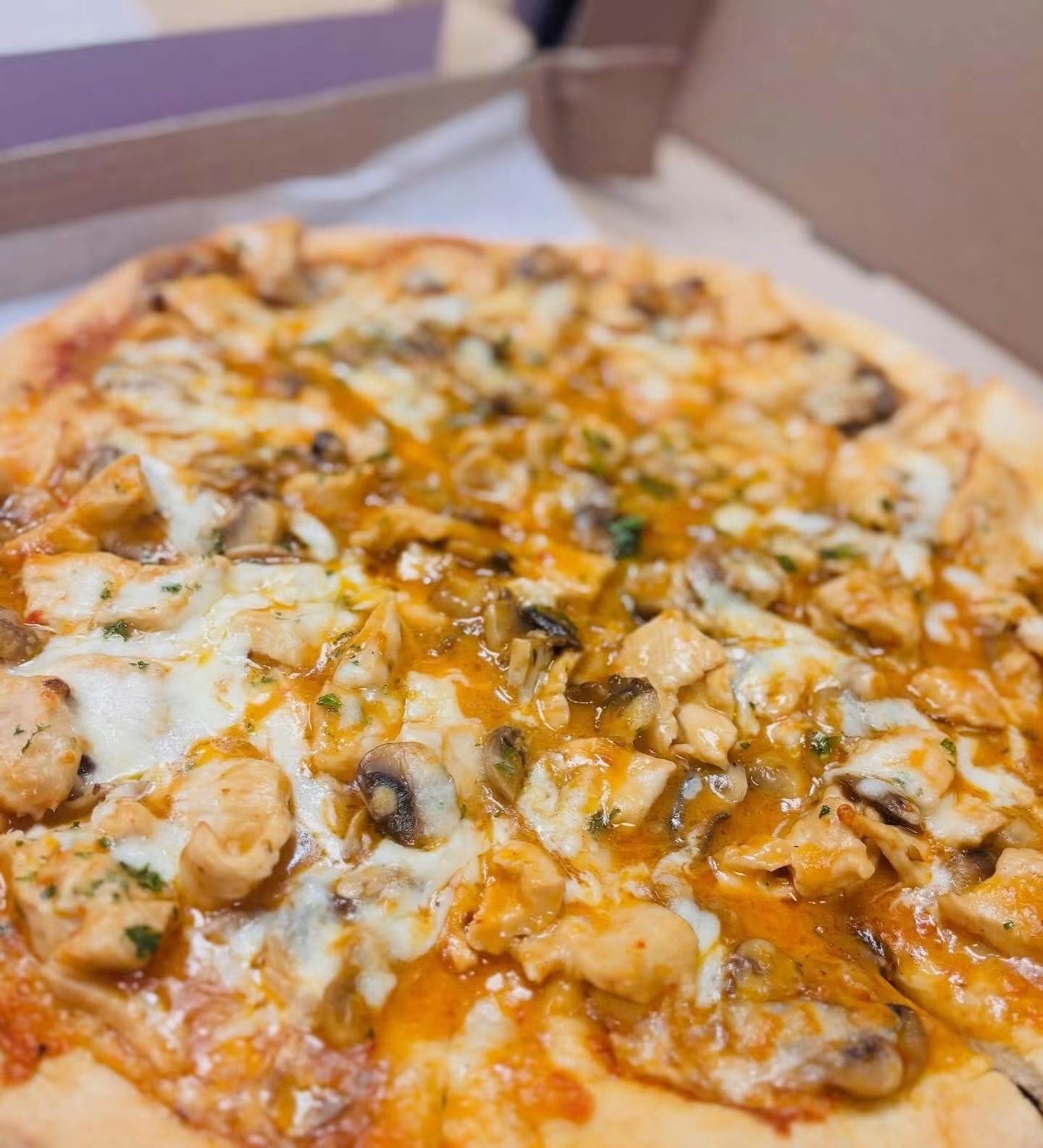 Specialty pizza topped with chicken and mushrooms