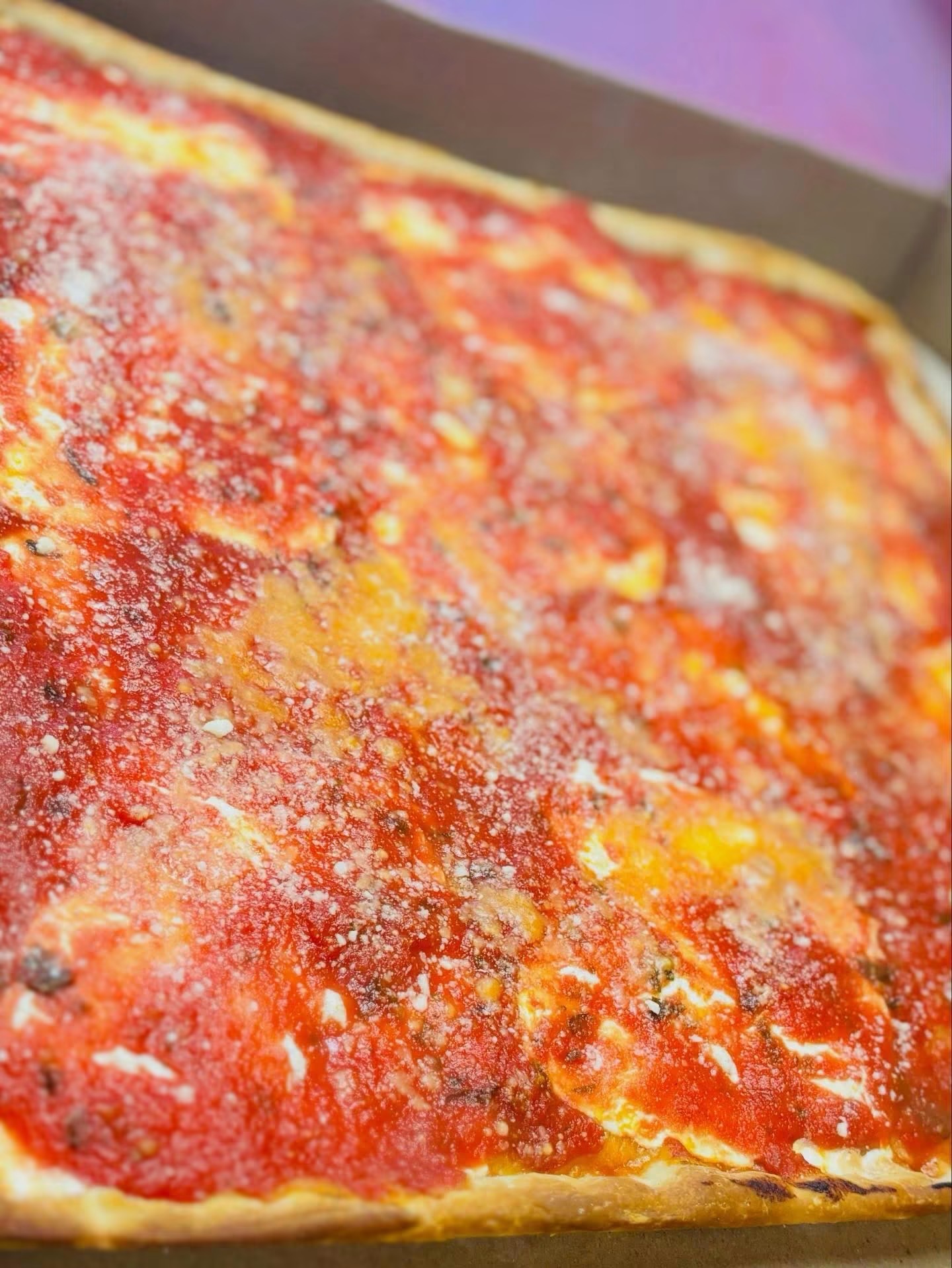 Grandma-style pizza with tomato sauce and grated cheese